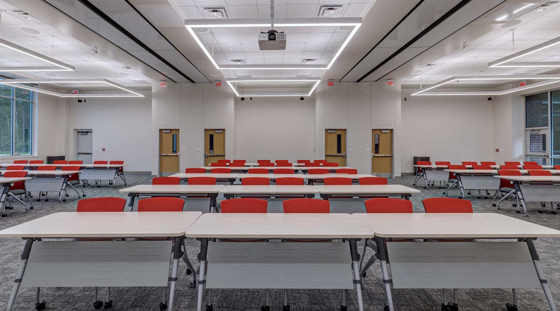 Flexible meeting space with mobile tables and seating arranged for group collaboration, featuring clean sightlines, integrated technology, and adaptable layouts to support presentations, training, and team discussions.