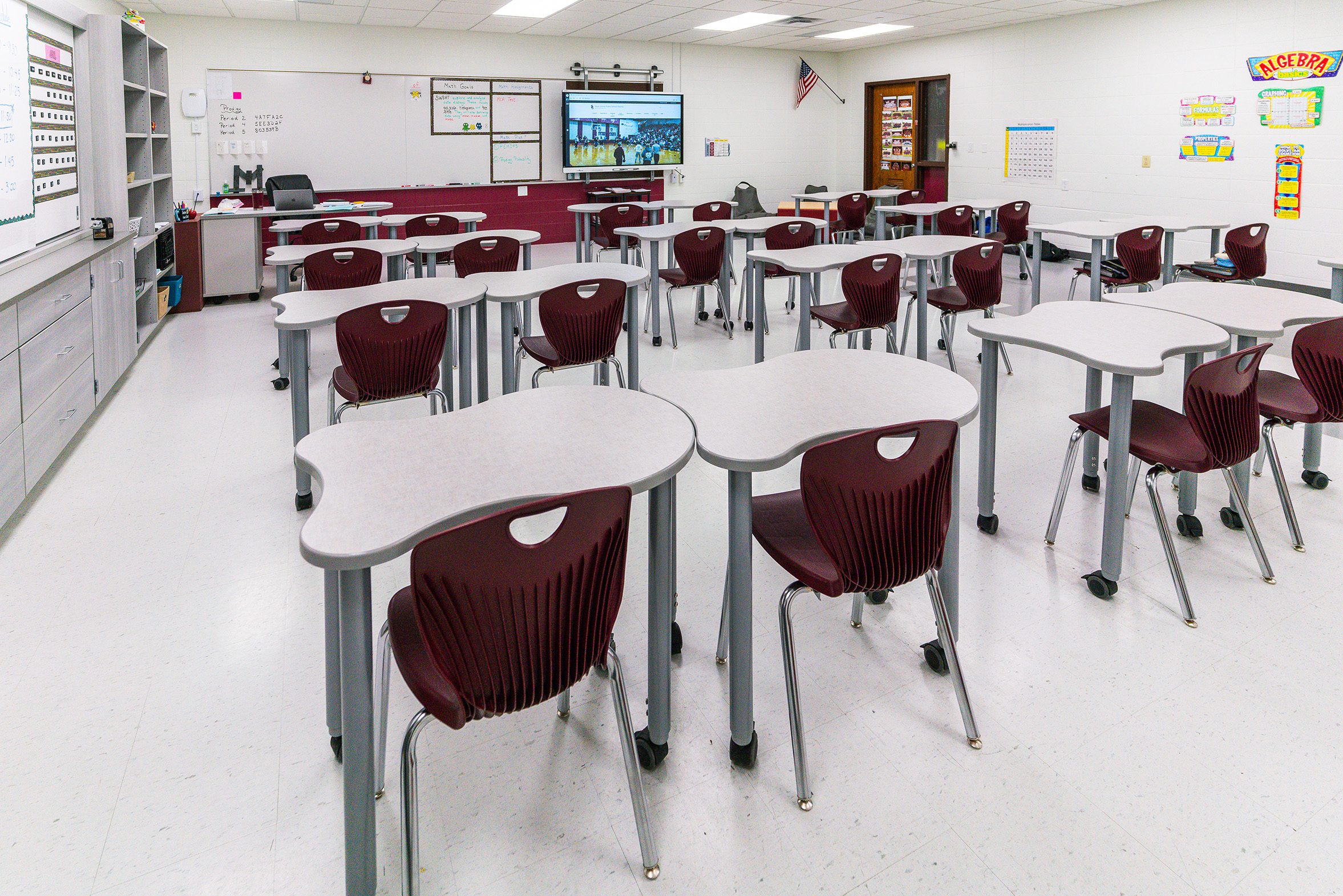 Classroom with individual student desks and maroon chairs arranged for flexible seating and group work.